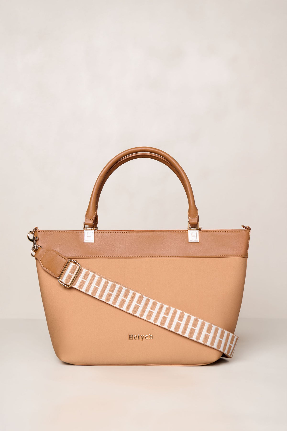Tan neoprene crossbody tote bag with handle and adjustable strap